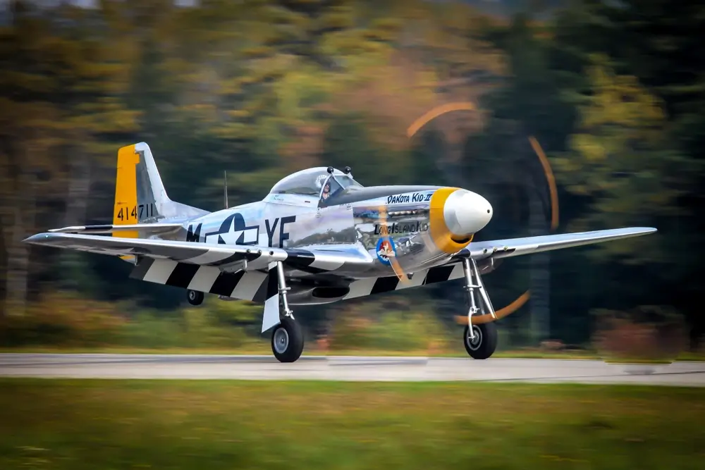 A P-51 Mustang lands at Wiscasset airport. Slow shutter speed and panning create this blurred effect.